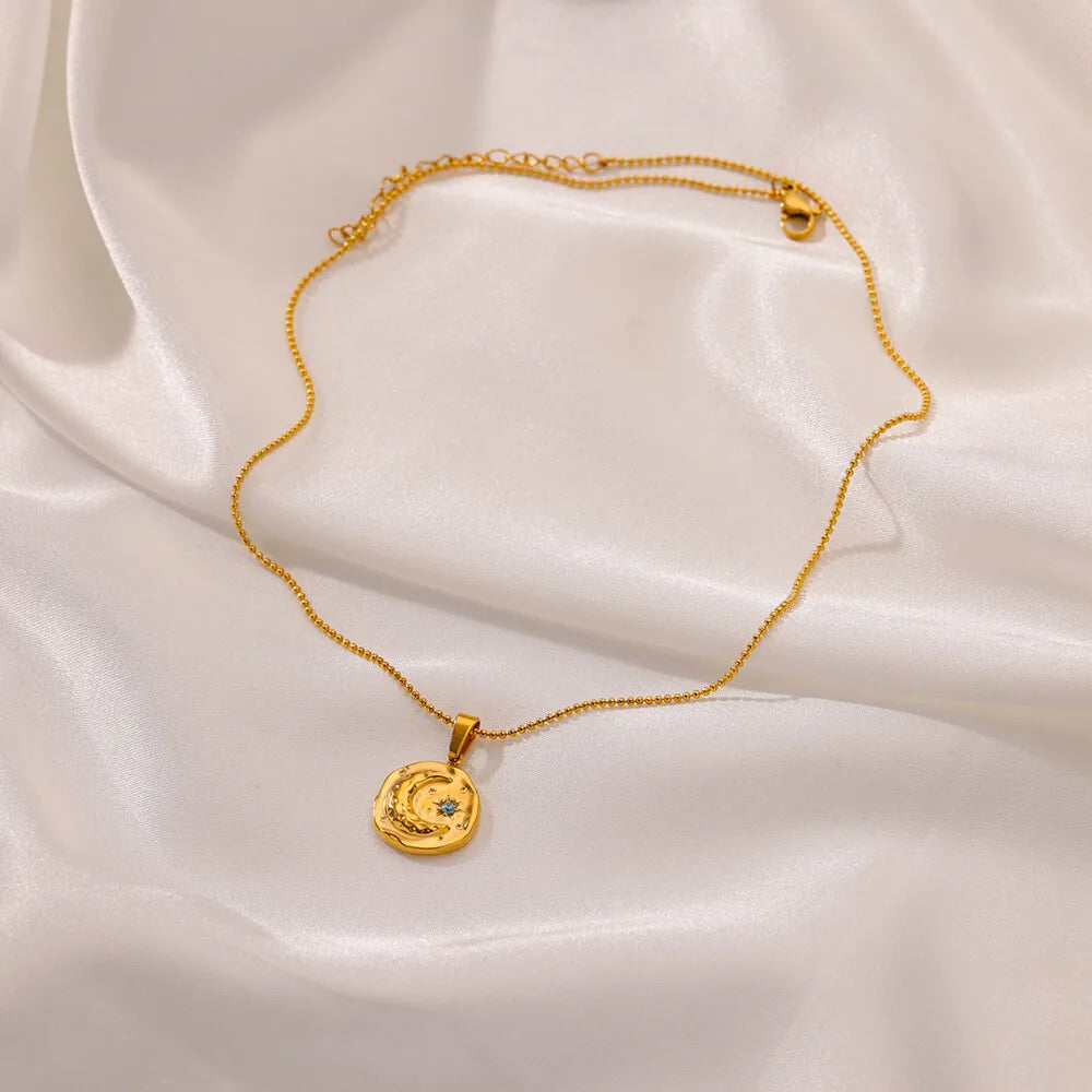 Collier avec pendentif croissant de lune et étoile sertie d'un zircon bleu