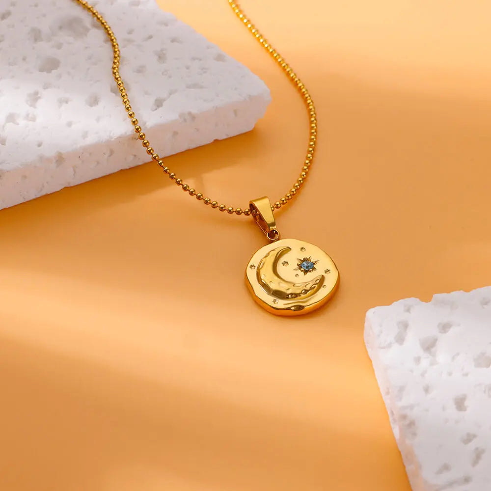 Collier avec pendentif croissant de lune et étoile sertie d'un zircon bleu